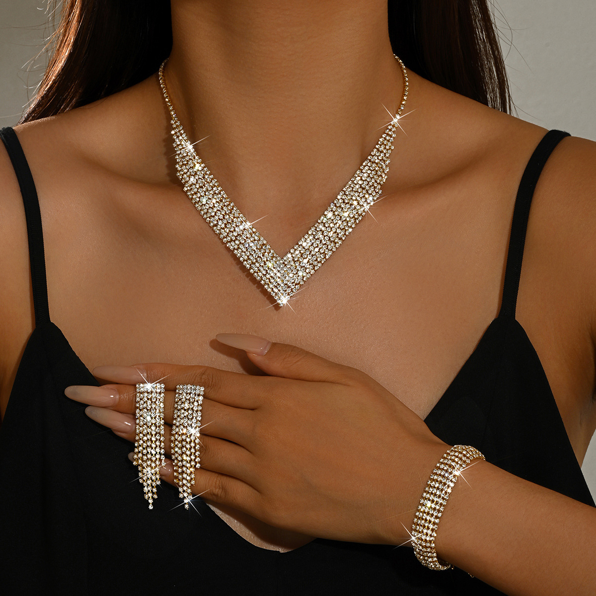 Set de bijuterii pentru femei, 3 piese, în nuanțe aurii, cu formă de V și ciucuri cu strasuri: colier, cercei atârnători și brățară; accesorii glam pentru
